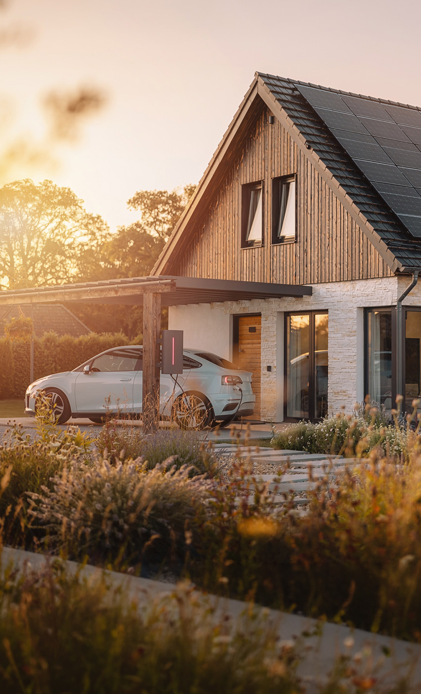 Photovoltaikanlage auf einem Einfamilienhaus mit Elektroauto vor dem Haus